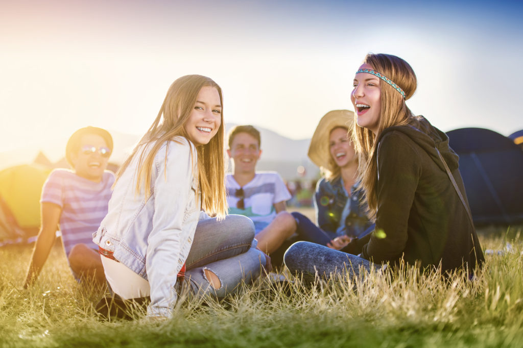 Group of beautiful teens camping at summer festival